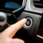Unrecognizable man pressing button to start engine of car