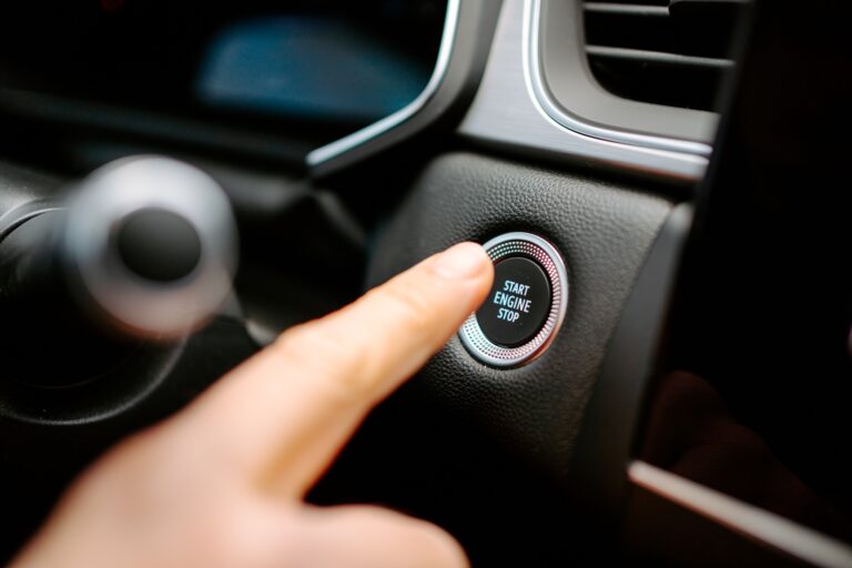 Unrecognizable man pressing button to start engine of car